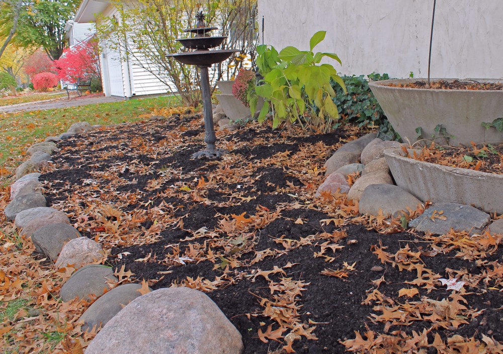 Our home was build many years ago by a local minister and architect, but when we moved in this area was covered with ivy and evergreens. The stones and containers sunk down into the dirt, so I had to dig all of the rocks out and clear away the ivy. I planted bee friendly spring bulbs in this areas. I then plan on putting food , flowers and herbs in this area. I have two areas out front to rotate crops each year. It should help the soil stay healthy! Those rocks were a project as after 40 yrs they sunk down deep!